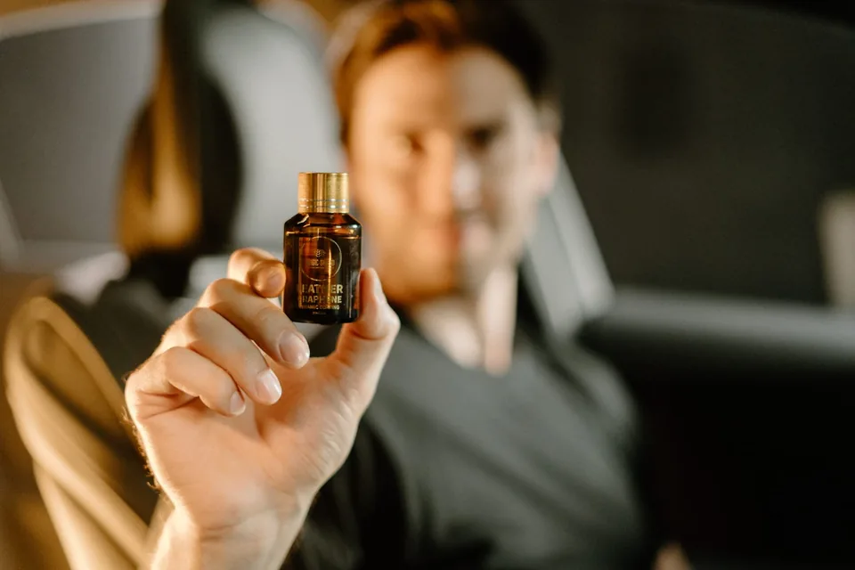 Person holding the Magic Shield Leather Graphene Ceramic Coating bottle inside a car